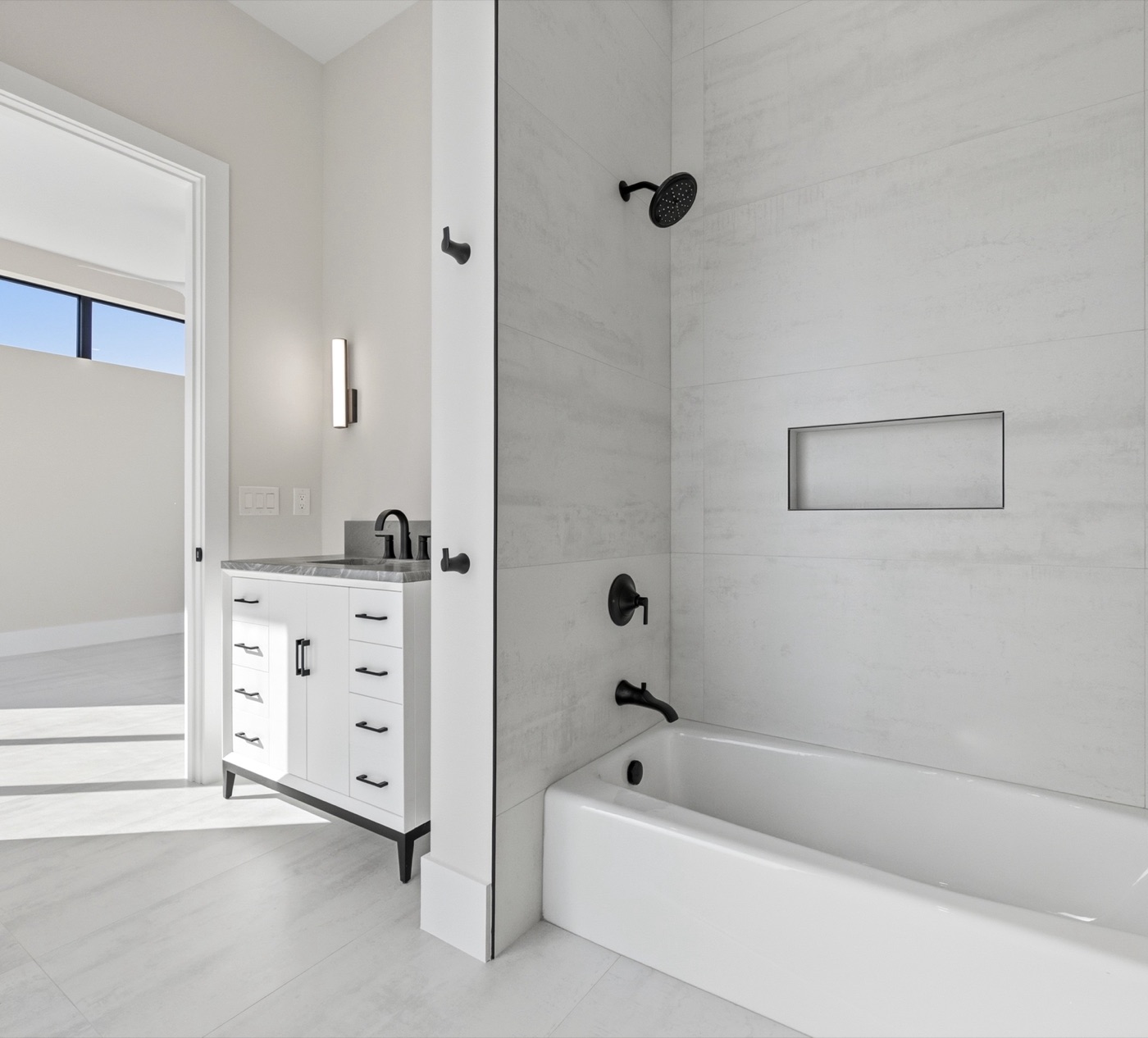 Clean modern bath with soft-gray porcelain surround and matte-black fixtures — Modern Residence