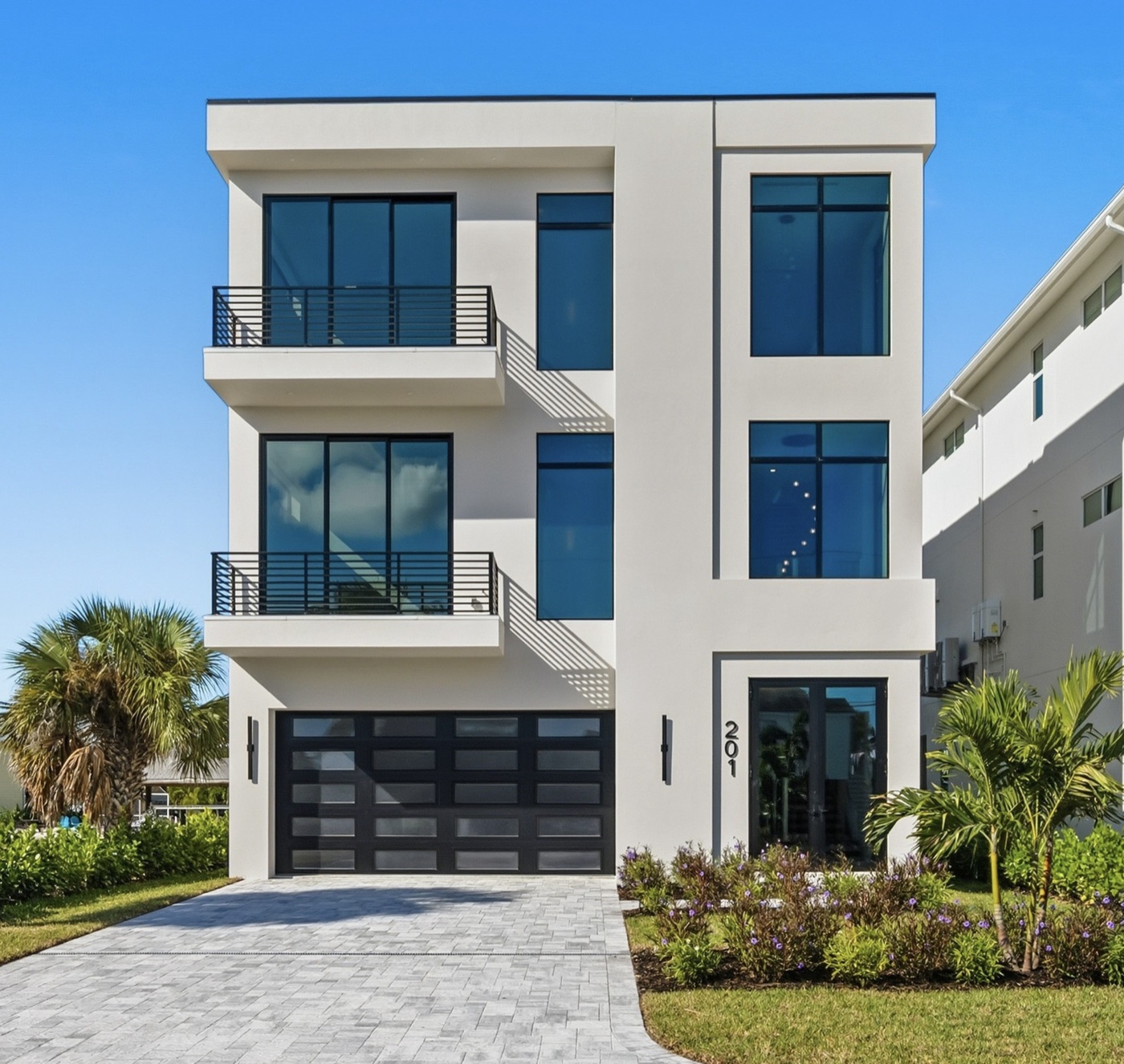 Modern three-story custom home with white stucco volumes and black-framed glass — Modern Residence by Afonova Nelson Homes