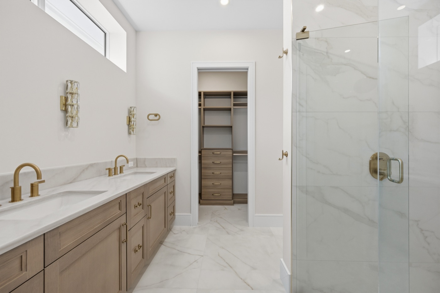 Spa-like primary bath with Calacatta marble shower and white-oak vanity — Coastal Residence